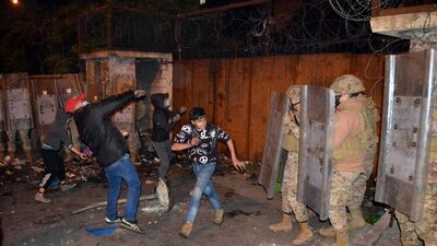 Lebanese anti-government protesters hurl rocks at the Serail, the headquarters of the Governorate of North Lebanon, in the northern port city of Tripoli. AFP