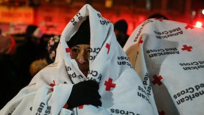 Evacuees wear blankets as they stand outside the apartment building that caught fire in New York's Bronx district on December 28, 2017. Amr Alfiky / Reuters