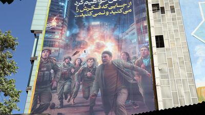 An anti-Israel billboard depicting people, among them Israeli soldiers, running away from an explosion and reading 'We will take revenge from where you imagine and not' hangs from a building in Palestine Square in Tehran. EPA