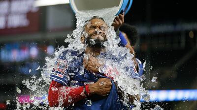 Texas Rangers' Delino DeShields receives an ice water shower from Elvis Andrus after hitting a game-winning RBI single in the 12th inning of the team's baseball game against the Baltimore Orioles. AP