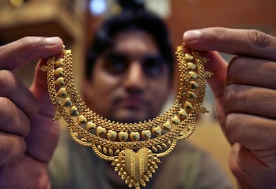 A salesman with a gold necklace at a jewellery shop in Jammu, India. Reuters