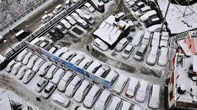 People walk past snow covered cars after heavy snowfall in the northern Indian city of Shimla. Reuters