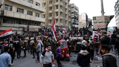 Iraqi protesters carry the Iraqi national flag as they gather on concret blocks which were used by security forces to close the Al-Khilani square in central Baghdad, Iraq. EPA