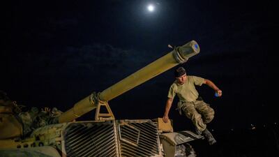 A man steps down from a tank as Turkish armed forces drive towards the border with Syria near Akcakale in Sanliurfa province. AFP