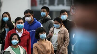 People wearing face masks to help curb the spread of the coronavirus walk out from a subway station entrance gate during the morning rush hour in Beijing. AP Photo
