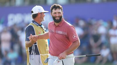 Jon Rahm of Spain shakes hands with his caddie, Adam Hayes on the 18th green. Getty Images