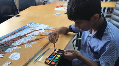 Children from Senses painting a Ghaf tree to be made into a carpet for Dubai Design Week. Courtesy Hands