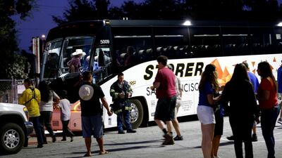Festival attendees are whisked away from the scene on buses. AP