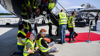 Environmental activists engage in a climate protest at the European Business Aviation Convention and Exhibition at Geneva Airport in Switzerland. EPA
