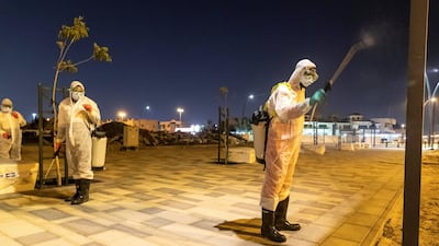 Sharjah Municipal staff spray and disinfect the sidewalk along the Al Muntazah Street area.