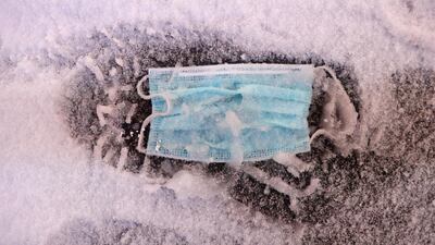 A face mask is seen on the ground as snow begins to fall in Times Square. Reuters