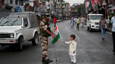A child presents an Indian flag to a member of the security forces to mark Independence Day in Jammu, in Jammu and Kashmir. AP Photo