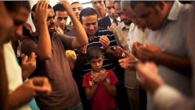 A son of the Muslim Brotherhood’s late spiritual leader Ammar Badie prays during his father's funeral in Al Hamed mosque in Cairo's Katameya district.