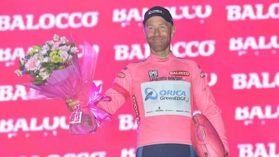 Canadian rider Svein Tuft of the Orica GreenEdge team wears the overall leader's pink jersey as he celebrates on the podium after his team won the first stage of the 2014 Giro d'Italia in Belfast on Friday. Luca Zennaro / EPA
