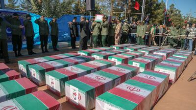Iranian mourners gather round coffins of victims of the bombings in Kerman at their funerals. Getty Images