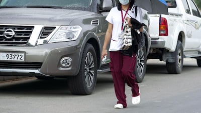 A healthcare worker on her way to work on a gloomy Monday morning at the Al Mushrif area of Abu Dhabi. Victor Besa / The National