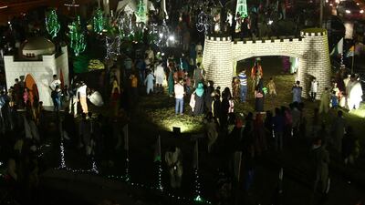 People visiting illuminated model representations of the Faisal Mosque ahead of Pakistan Independence Day celebrations in Karachi. EPA