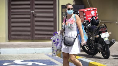 A grocery shopper at Souk Planet, Khalifa City. Face masks should be worn at all times when outside the home, the UAE government said on Saturday. Victor Besa / The National