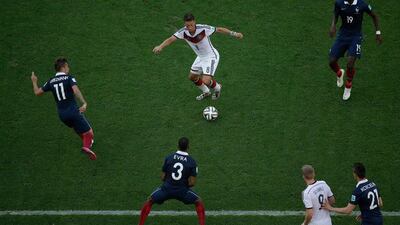 Mesut Ozil, centre, of Germany dribbles around French players while Andre Schurrle, No 9, looks on during Germany's quarter-finals victory over France at the 2014 World Cup on Friday. Matt Dunham / AP / July 4, 2014