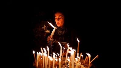 A woman blows on candles inside the Church of the Holy Sepulchre in the Old City of Jerusalem. AFP