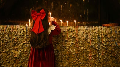 A girl lights a candle during a Christmas Eve service at the Syriac Catholic Cathedral of the Sacred Heart in Iraq's southern city of Basra. AFP