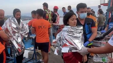 Emergency responders assist victims of a ferry accident as they arrive at the port in Isabela, Philippines. AFP