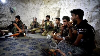 Fighters with the Free Syrian army eat in a cave where they live, in the outskirts of the northern town of Jisr al-Shughur, Syria, west of the city of Idlib. AP