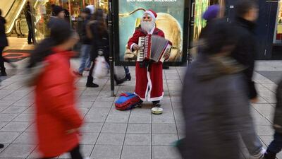 Sweden: People walk past a street performer dressed as Santa Claus ahead of Christmas at Drottninggatan in central Stockholm. Reuters/Henrik Montgomery/TT News Agency