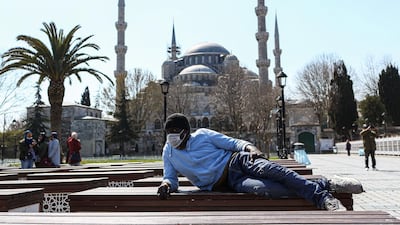 A man wearing a protective face mask rests in front of the Sultanahmet Mosque in Istanbul, Turkey. EPA