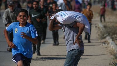 People rush for a share of aid after Israel eased a full blockade imposed on the besieged Palestinian territory for over two months. AFP