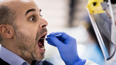 A health worker dressed in personal protective equipment (PPE) takes an oral swab sample from a passenger in a Covid-19 screening area at Debrecen International Airport in Debrecen, Hungary. Hungarians may take part in the clinical trial of Russia’s Sputnik V coronavirus vaccine, according to the top health official of the eastern European Union member state. Bloomberg