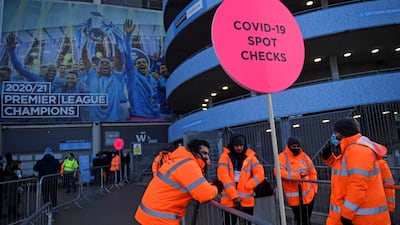 Stewards wait to check fans' NHS Covid-19 passes or proof of a negative test result, as they arrive to watch the English Premier League football match between Manchester City and Chelsea at the Etihad Stadium in Manchester. AFP
