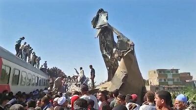 People gather around the wreckage of two trains that collided in the Tahta district of Sohag province in March. AFP