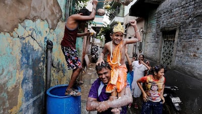 A man carries his son who is dressed up as Hindu Lord Krishna in Ahmedabad. Amit Dave / Reuters