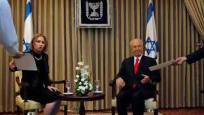 Tzipi Livni with Shimon Peres in Jerusalem. Below, medics evacuate a wounded soldier from the scene of Monday's attack.