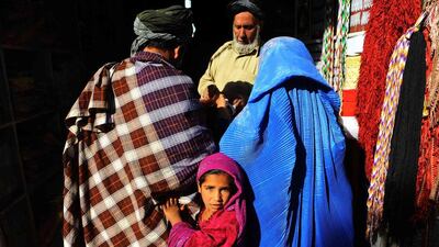 An Afghan girl accompanies her parents shopping in a market in Herat ahead of the feast of Eid Al Adha. Aref Karimi / AFP