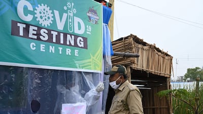 A health worker takes a swab sample for the coronavirus from a policeman as pilgrims begin arriving for the Hindu religious festival of Gangasagar Mela on Sagar Island, about 150 kilometres south of Kolkata, West Bengal. AFP