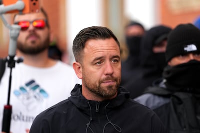 Anti-migrant activist Daniel Thomas with some of his masked Patriot Platform supporters. Getty Images