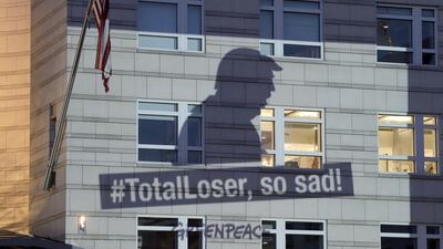 A Greenpeace banner showing US President Donald Trump and the slogan '#TotalLoser, so sad!' is projected onto the facade of the US embassy in Berlin, Germany, Friday, June 2, 2017, a day after Trump declared he was pulling the US from the landmark Paris climate agreement,. Michael Sohn / AP
