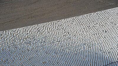 Some of the 300,000 computer-controlled mirrors, each about 7 feet high and 10 feet wide, reflect sunlight to boilers that sit on 459-foot towers. Ethan Miller / Getty Images / AFP