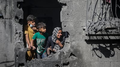 A Palestinian family look at their destroyed house following an Israeli airstrike on Al Shatea refugee camp in Gaza city on Wednesday. EPA