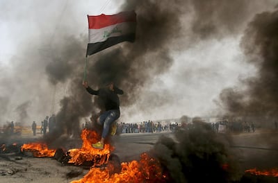 An Iraqi demonstrator jumps over a burning tyre during anti-government protests in Basra, Iraq in December. Reuters
