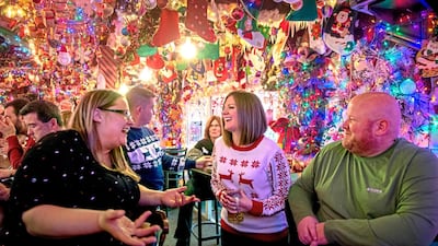 Friends follow a holiday tradition by gathering under approximately 10,000 lights decorating Bob's Garage in O'Hara Township, Pittsburgh. AP