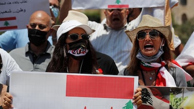 Anti Hezbollah protesters shout slogans and hold placards with the UN Resolution 1559, which was adopted in Sept 2004, that called for disarmament of all Lebanese and non-Lebanese militias, during a sit-in against Hezbollah and Iran in front the UN headquarters, in Beirut, Lebanon, July 24. Hussein Malla/ AP