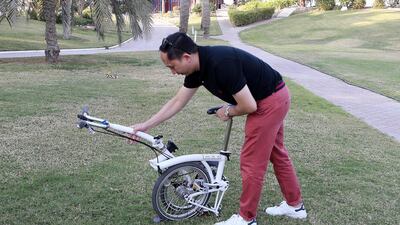 Moises Dacuycuy shows how to open a folding cycle. Pawan Singh / The National
