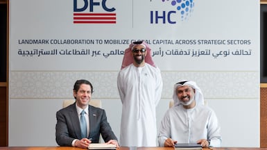 Sheikh Tahnoon bin Zayed, chairman of International Holding Company, Deputy Ruler of Abu Dhabi and National Security Adviser, centre, with IHC chief executive Syed Shueb, right, and DFC chief executive Ben Black at the signing ceremony in Abu Dhabi. Photo: IHC