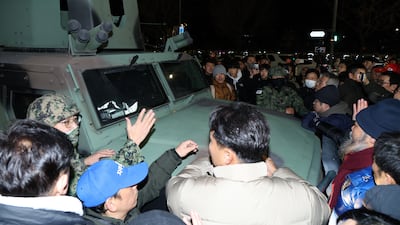 People surround a military vehicle. EPA