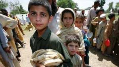 Children line up to receive food in a refugee camp near Mardan.