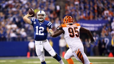 Indianapolis Colts quarterback Andrew Luck throws a pass as he's chased down by Cincinnati Bengals defender Wallace Gilberry during his team's NFL play-off win on Sunday. Steven C Mitchell / EPA / January 4, 2015