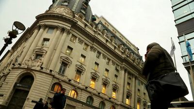 People walk by a bank in Buenos Aires’ financial district. Despite central bank measures, the peso lost a further 13.5 per cent by the close of Thursday. REUTERS